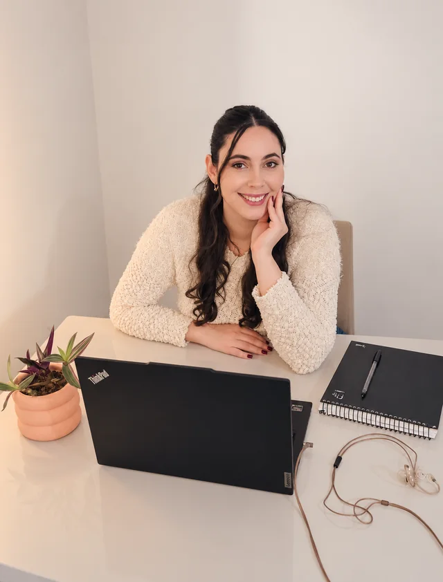 Jheniffer Lorraine em seu espaço de atendimento online, com notebook sobre a mesa